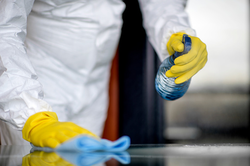 Table disinfection.
Covid-19 Wiping down surfaces. Woman with gloves and disinfectant wipe sanitizing the desk to prevent germs and bacteria infections