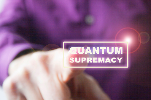 Pressing a virtual quantum supremacy button a right hand of a Caucasian man in purple shirt, as a concept of overcoming quantum computers to classics.