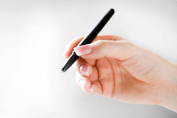 istock Woman hand holding black pen. 1212586274