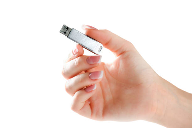 Woman hand holding silver usb in finger with beatiful nails. Flash drive holding in hand isolated.