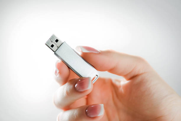 Woman hand holding silver usb in finger with beatiful nails. Usb data storage in woman hand. Usb flash drive in hand with white background. usb stick photos stock pictures, royalty-free photos & images