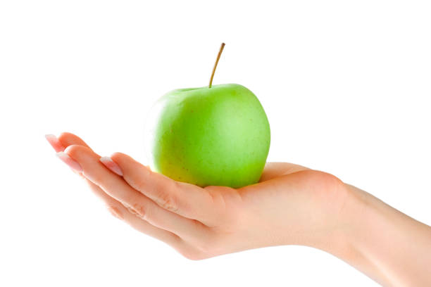 This is a clean simple image of a hand holding an apple with a lot of copy space. The image is styled in a warm retro tone to make it look vintage.