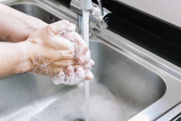 istock hands of a man washing in a pile with soap foam 1212586708