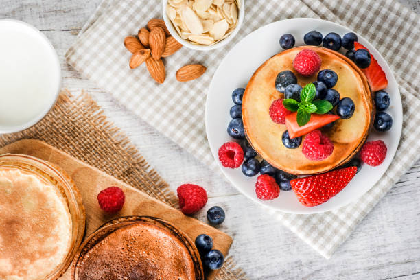 istock Pancakes with forest fruits berries on white table. 1212589007