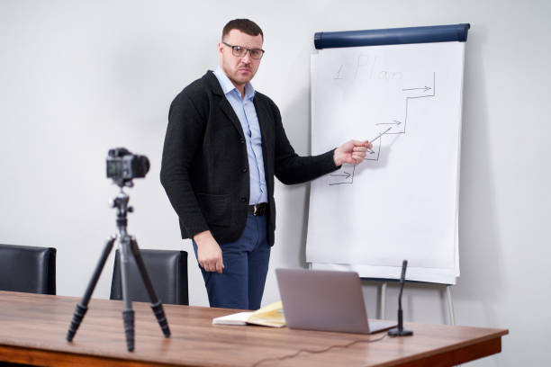 istock Young video blogger presenting important data on flipchart, online education concept 1212589162