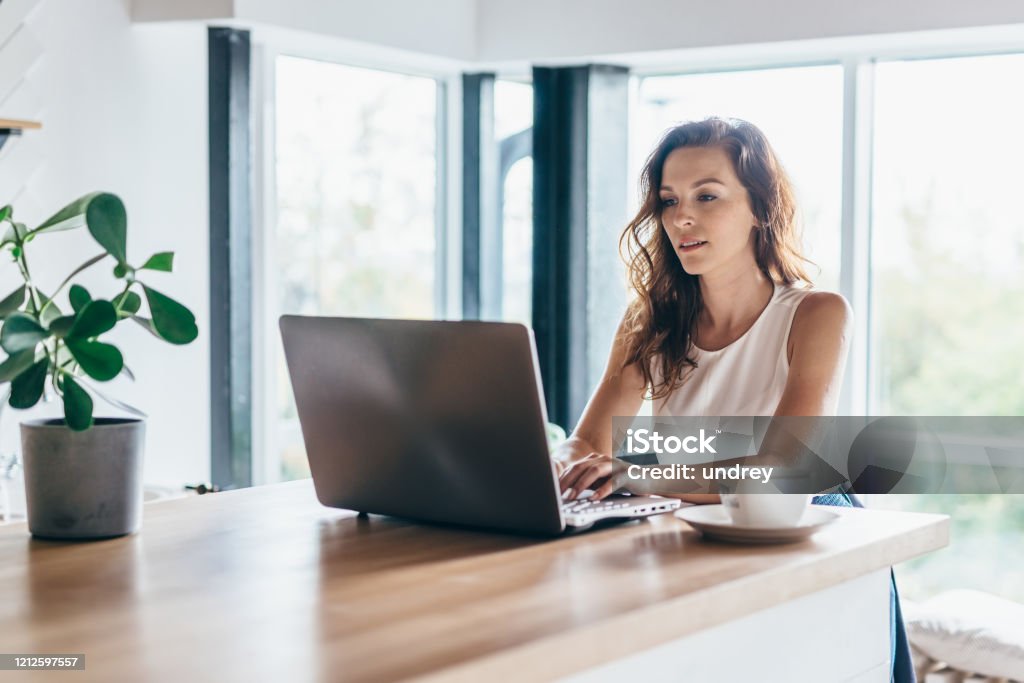 집에 앉아있는 동안 노트북을 사용하는 여자 - 로열티 프리 노트북 스톡 사진
