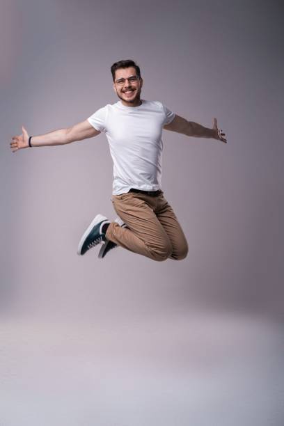 istock handsome man casual dressed celebrating and jumping on gray background 1212599639