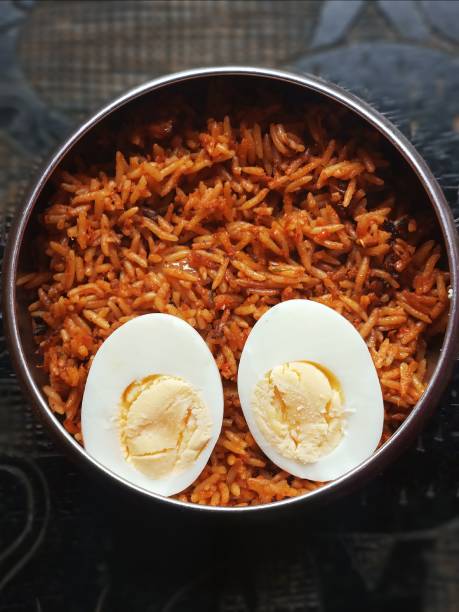 arroz jollof nigeriano con huevos hervidos - cooked still life close up rice fotografías e imágenes de stock