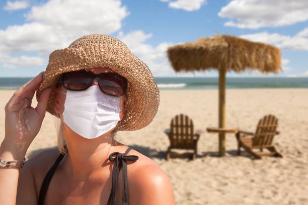 istock Vacationing Woman Wearing Face Mask on Sandy Beach. 1212602712