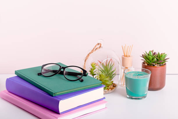 istock Multicolor books stack, house plants succulents and fragrant candle and sticks. Background for World Book Day. Still life with stack of colorful books and home interior decor 1212605057
