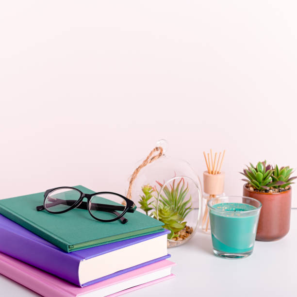 istock Multicolor books stack, house plants succulents and fragrant candle and sticks. Background for World Book Day. Still life with stack of colorful books and home interior decor 1212605073