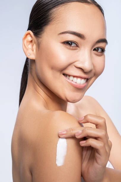 istock Happy pretty female applying lotion on hand 1212609373