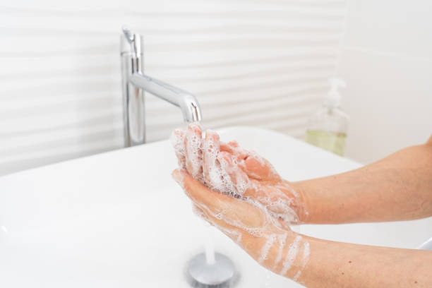 istock Woman washing her hands in bathroom 1212609467