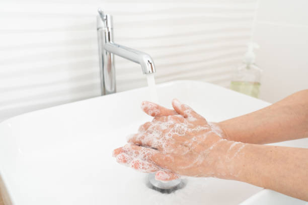 istock Woman washing her hands in bathroom 1212609492
