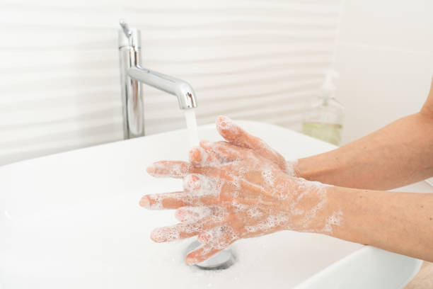 istock Woman washing her hands in bathroom 1212609521