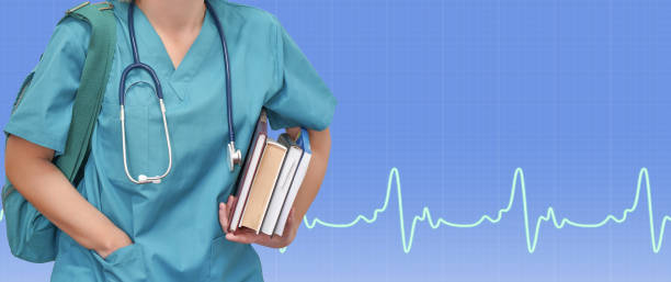 chirurgo tirocinante femminile in uniforme blu con libri e borsa su elettrocardiogramma a sfondo blu. medico su sfondo sanitario blu. striscione per l'assistenza sanitaria. - medical student immagine foto e immagini stock