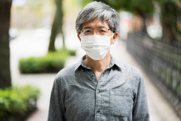 istock Senior man with mask walking on the street 1212614655