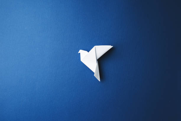 istock Paper pigeon on a blue isolated background. 1212618833