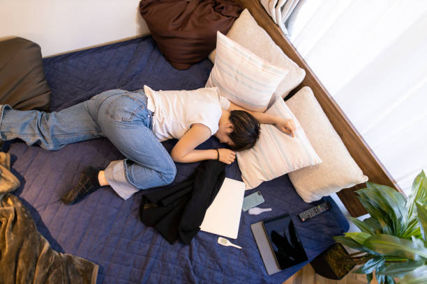 giovane donna sdraiata sul letto al mattino - smart phone china mobile phone asia foto e immagini stock