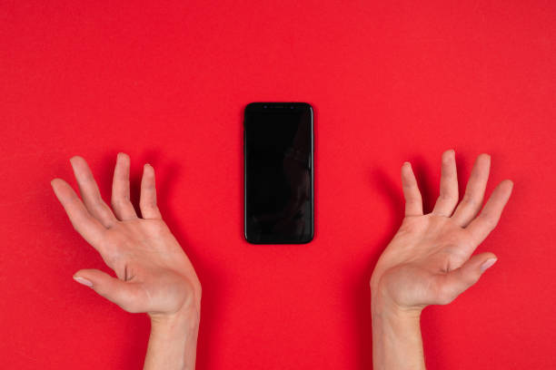 istock Hands holds a phone isolated on red background 1212622375