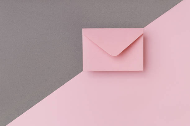 istock Pink envelope on the double colored pink and grey background. Mail concept 1212623035