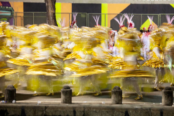 Carnival participants performing on street, blurred motion.