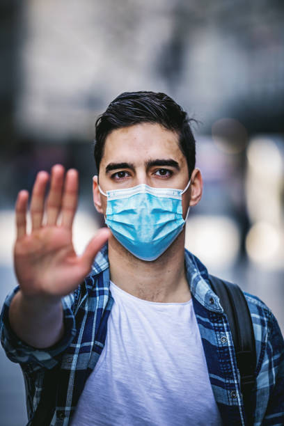 istock Stop the infection! Man with a mask gesturing stop 1212626892