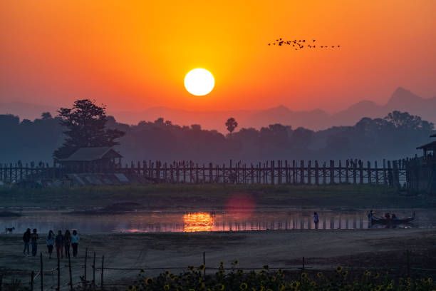 U Bein Bridge at sunrise, Taung Tha Man Lake, Amarapura U Bein Bridge at sunrise, Taung Tha Man Lake, Amarapura, Mandalay Region, Myanmar Amarapura stock pictures, royalty-free photos & images