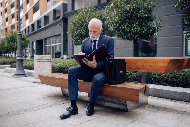 istock Mature gentleman sitting on the bench 1212627058