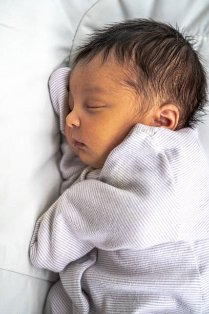 A Cute Adorable Newborn Mixed Race Infant Baby Girl With Dark Brown Hair Sleeping On Her Side In Her Peacefully With Her Eyes Stock Photo - Download Now - iStock