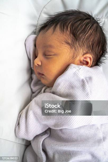 A Cute Adorable Newborn Mixed Race Infant Baby Girl With Dark Brown Hair  Sleeping On Her Side In Her Bassinet Peacefully With Her Eyes Closed Stock  Photo - Download Image Now - iStock