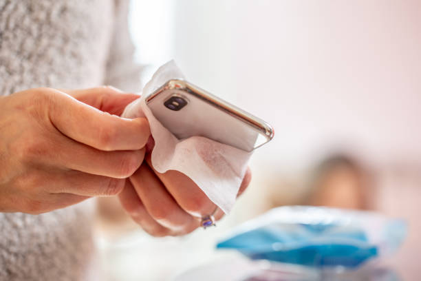 Reinigung eines Mobiltelefons mit einem Einweg-Antibakterielles Tuch während Coronavirus Notfall – Foto