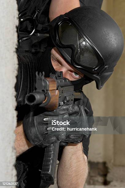 Soldier In Black Mask Targeting With Ak47 Rifle From Cover Stock Photo - Download Image Now