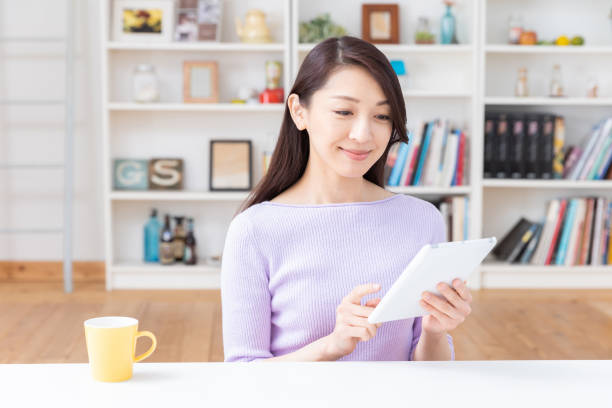 istock asian woman to see a tablet computer 1212633294