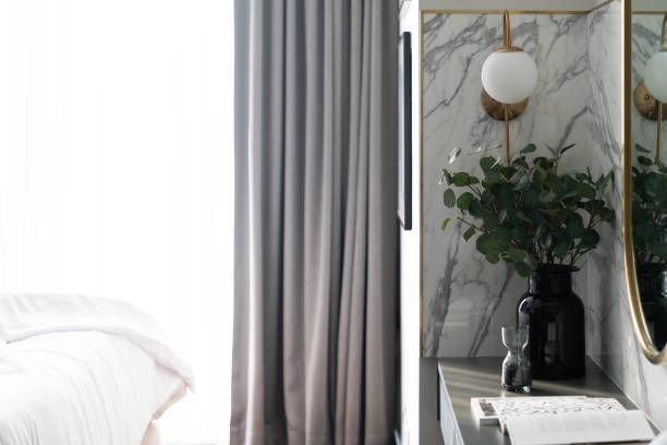 istock Bedroom working corner decorated with gold stainless mirror and artificial plant in glass vase on gray spray-painted  working table with  marble wall background /apartment interior /copyspace 1212636421