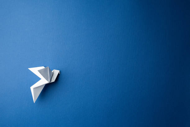 istock Paper pigeon on a blue isolated background. 1212637904