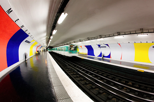 Departing train in mostly empty station, Assemblée-National Metro station, Paris, France, Europe