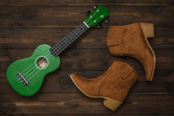 istock Suede boots and a green ukulele on a wooden background. 1212640649