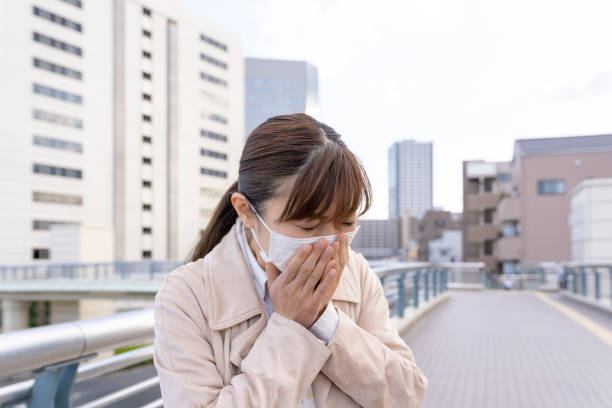 Asian business people wearing medical mask, sneezing stock photo