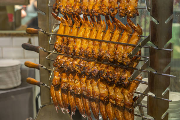 ailes de poulet rôties sur la machine de grillage dans le restaurant chinois - vietnam market asia bird photos et images de collection