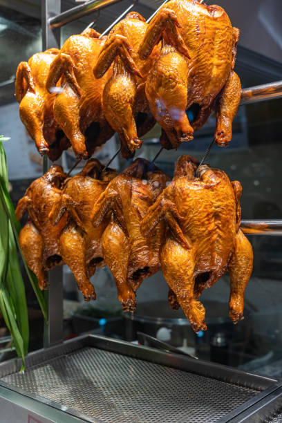 frangos assados inteiros pendurados na vitrine do restaurante chinês - vietnam market asia bird - fotografias e filmes do acervo