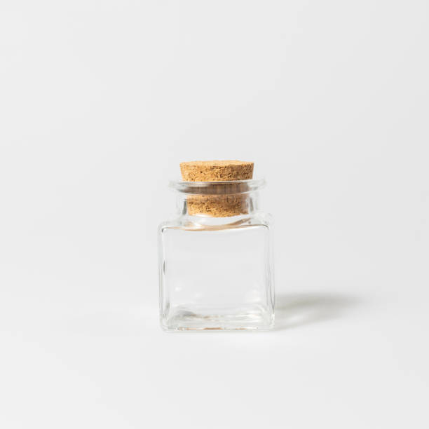 istock front view of transparent empty glass jar bottle with closed brown cork cap lids on white background 1212646571