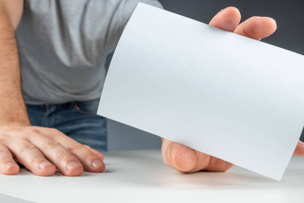 istock Close-up male hand holds a white card, mockup, layout, copy space. 1212647371
