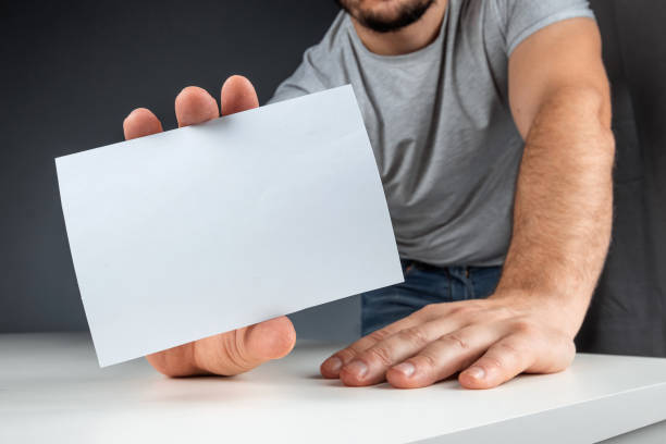 istock Close-up male hand holds a white card, mockup, layout, copy space. 1212647373