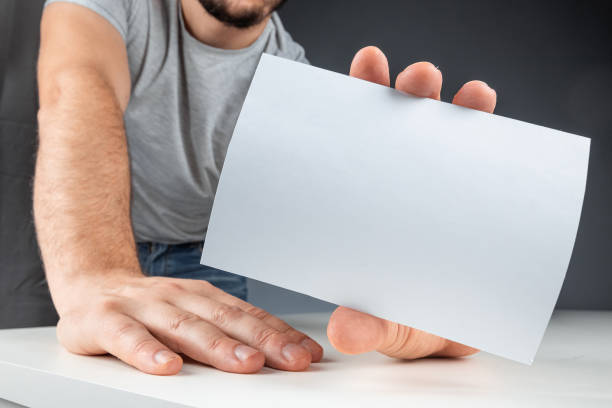 istock Close-up male hand holds a white card, mockup, layout, copy space. 1212647378