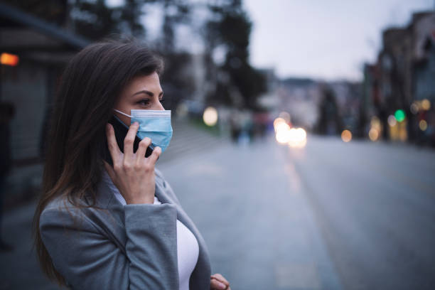 istock Woman With Protective Mask Talking On The Phone 1212647412
