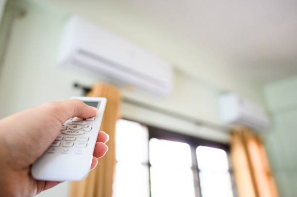 istock Concept of save power energy save sustainability world. Hand push down button air conditioner remote and turning off working machine 1212648100