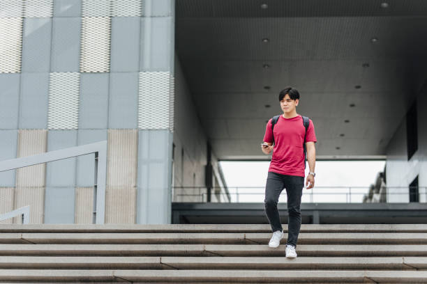 istock Staying Connected on the CampusL Student Walking Downstairs Holding a Smartphone 1212648449