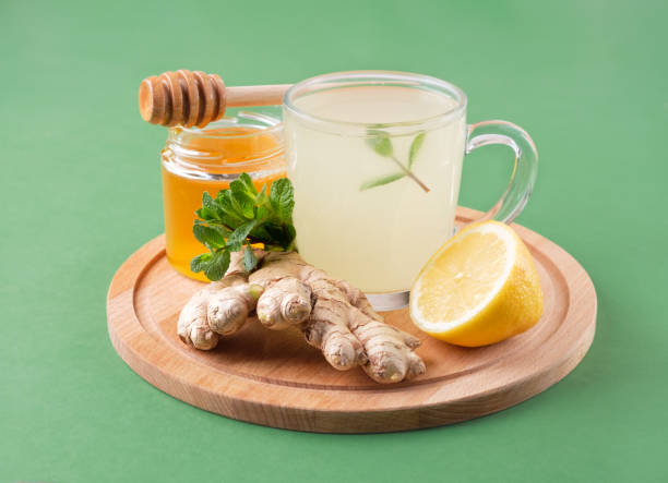 istock Ginger tea with honey , lemon and mint on green background. Virus protection 1212655026