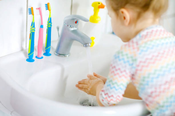 primo piano della bambina che si lava le mani con acqua e sapone in bagno. primo passo bambino apprendimento pulizia parti del corpo. azione di routine igienica durante la malattia virale. bambino a casa o all'asilo nido. - home interior sparse bedroom inside of foto e immagini stock